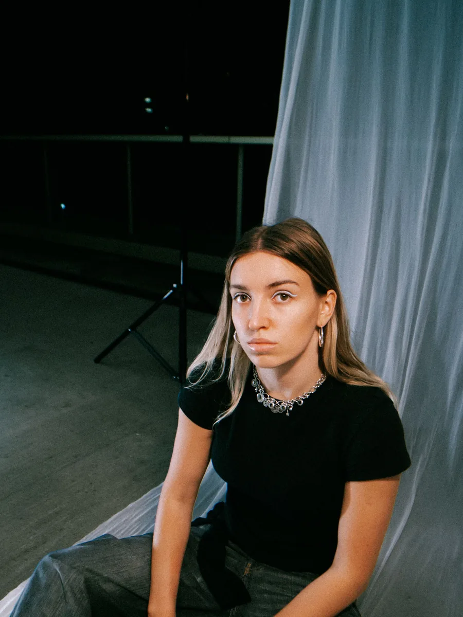Anya, founder of AUCH Studio, sitting in front of a white backdrop.